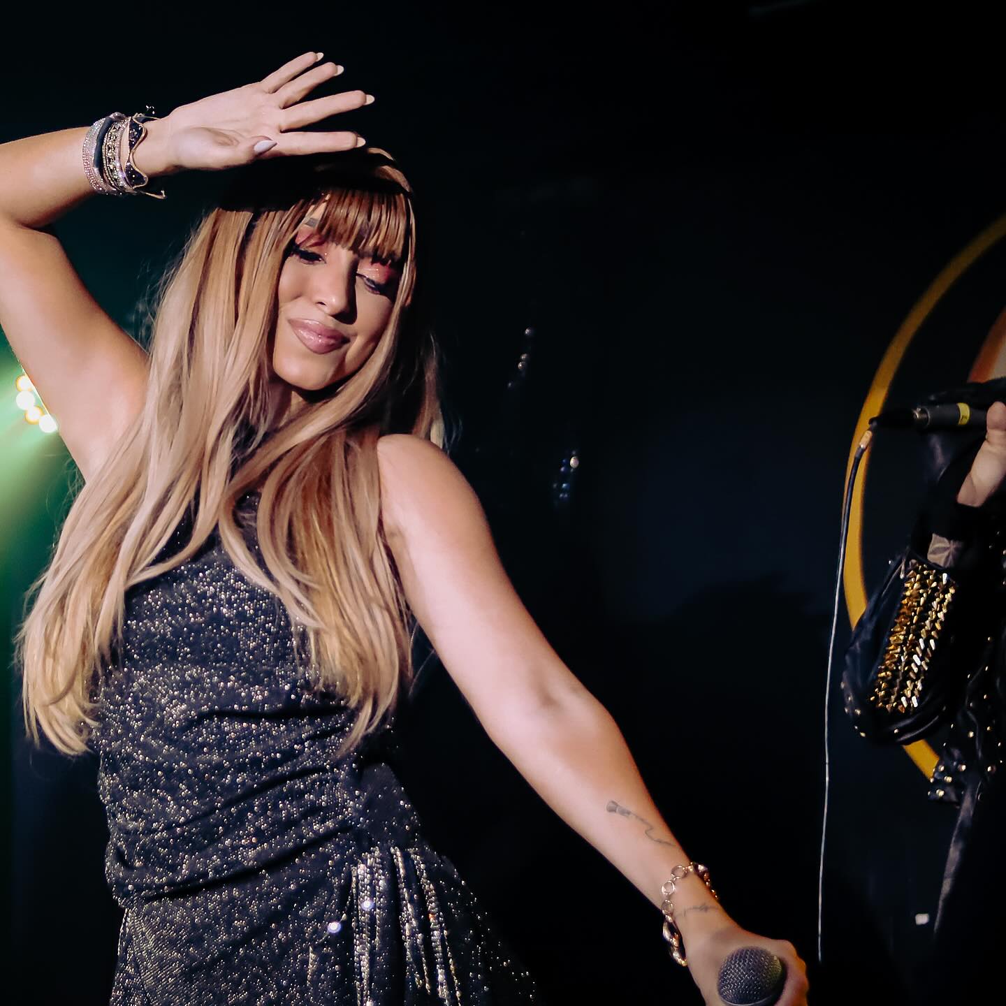 Jessy Portilla no palco em movimento, com vestido brilhante